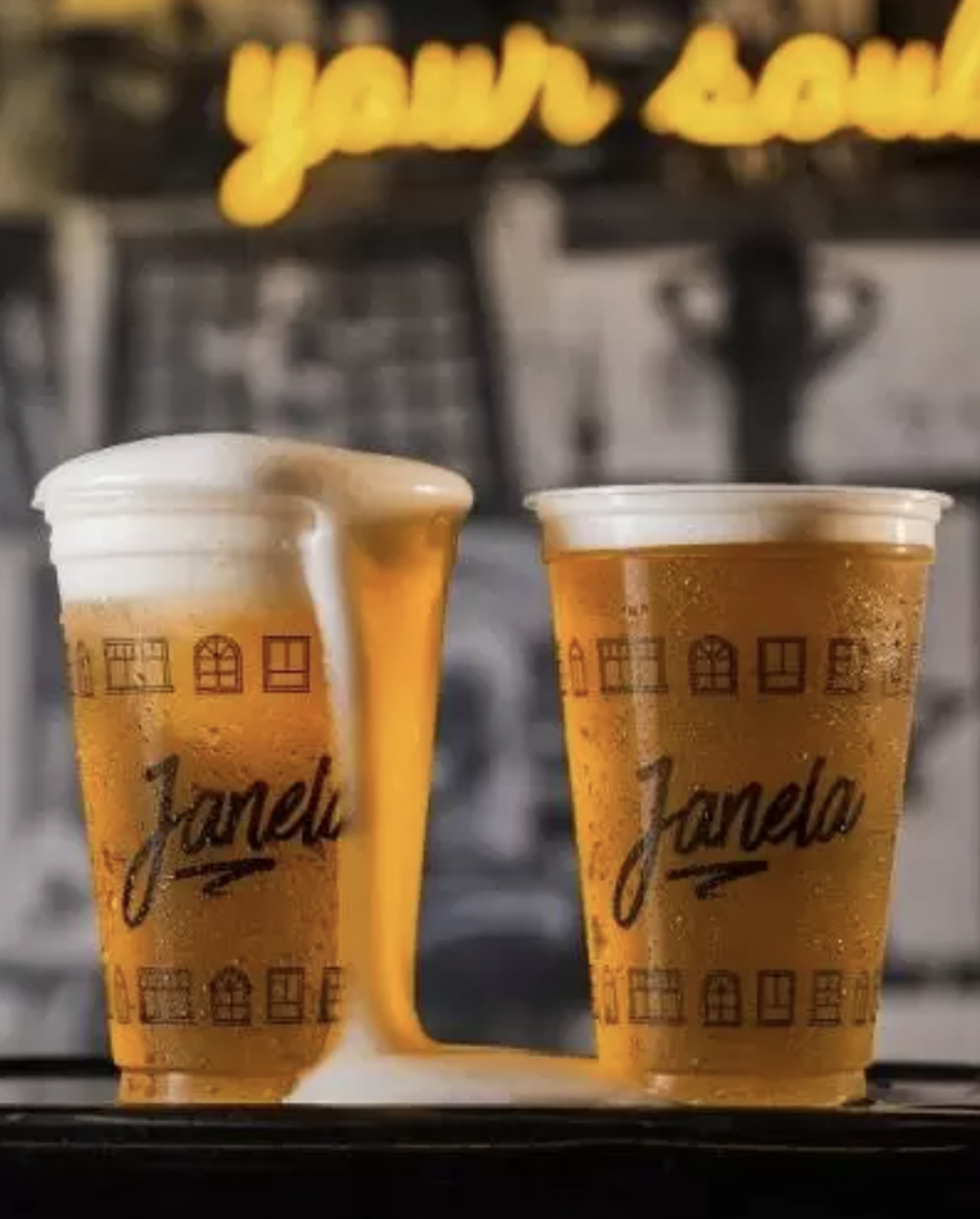 Dois copos de chope gelado com colarinho, servidos no balcão do bar O Janela Itajaí