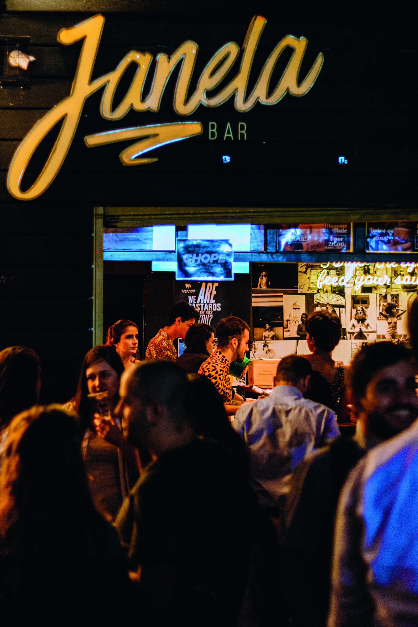 Galera reunida no balcão do bar O Janela em uma noite cheia