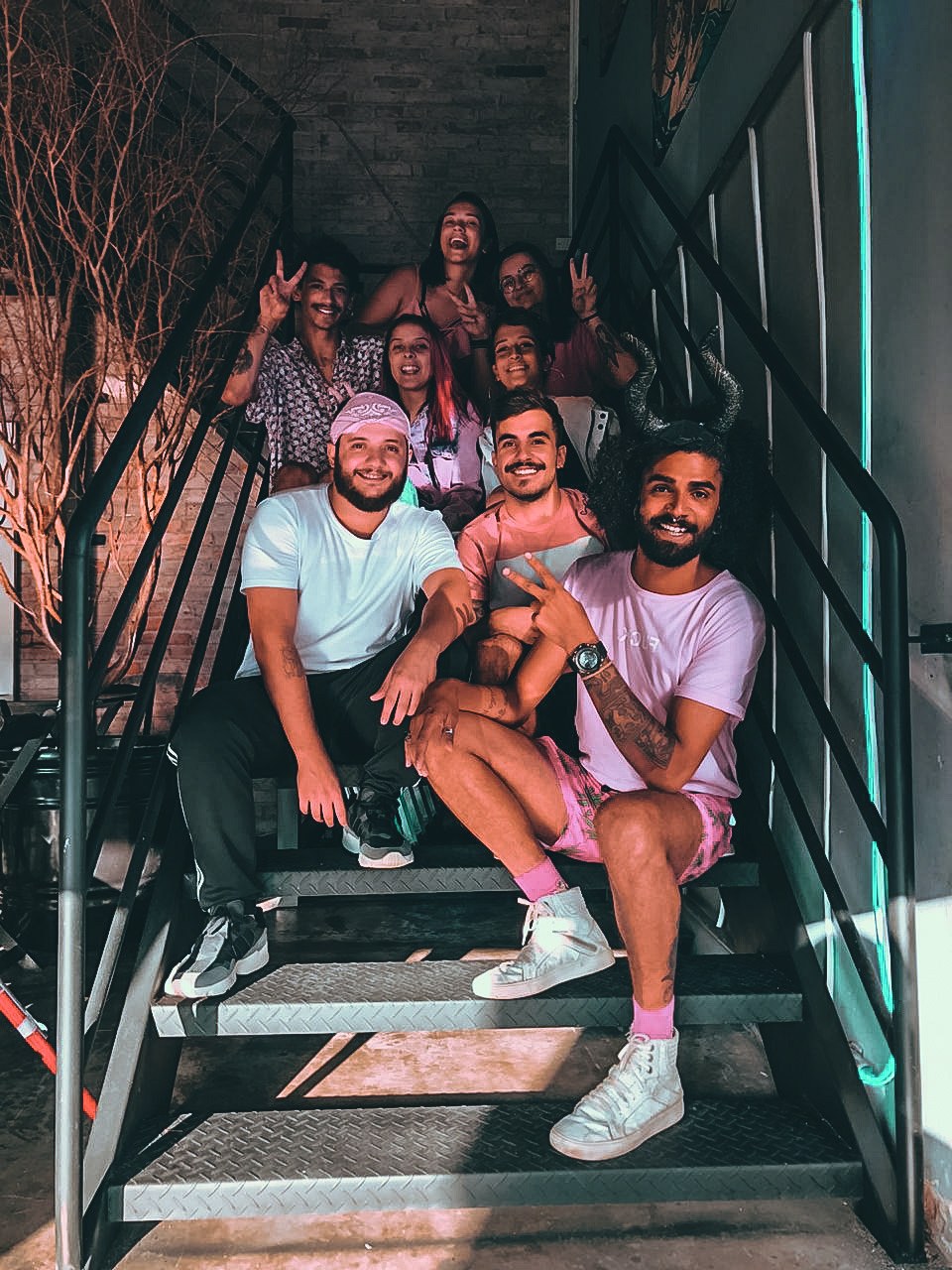 Grupo de amigos posando na escada do Janela em clima de comemoração